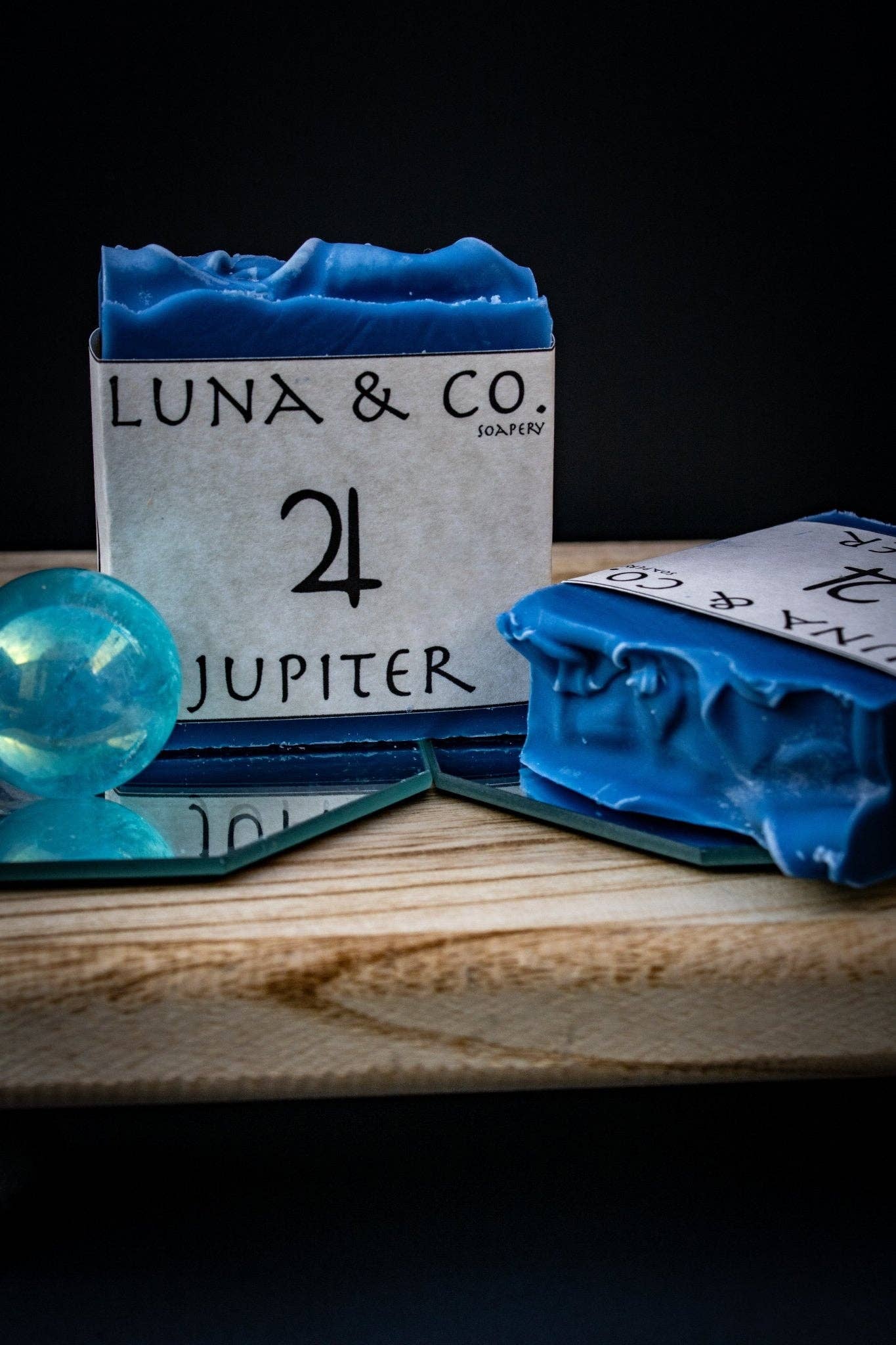 Blue soap bars with 'LUNA & CO.' packaging on a wooden surface