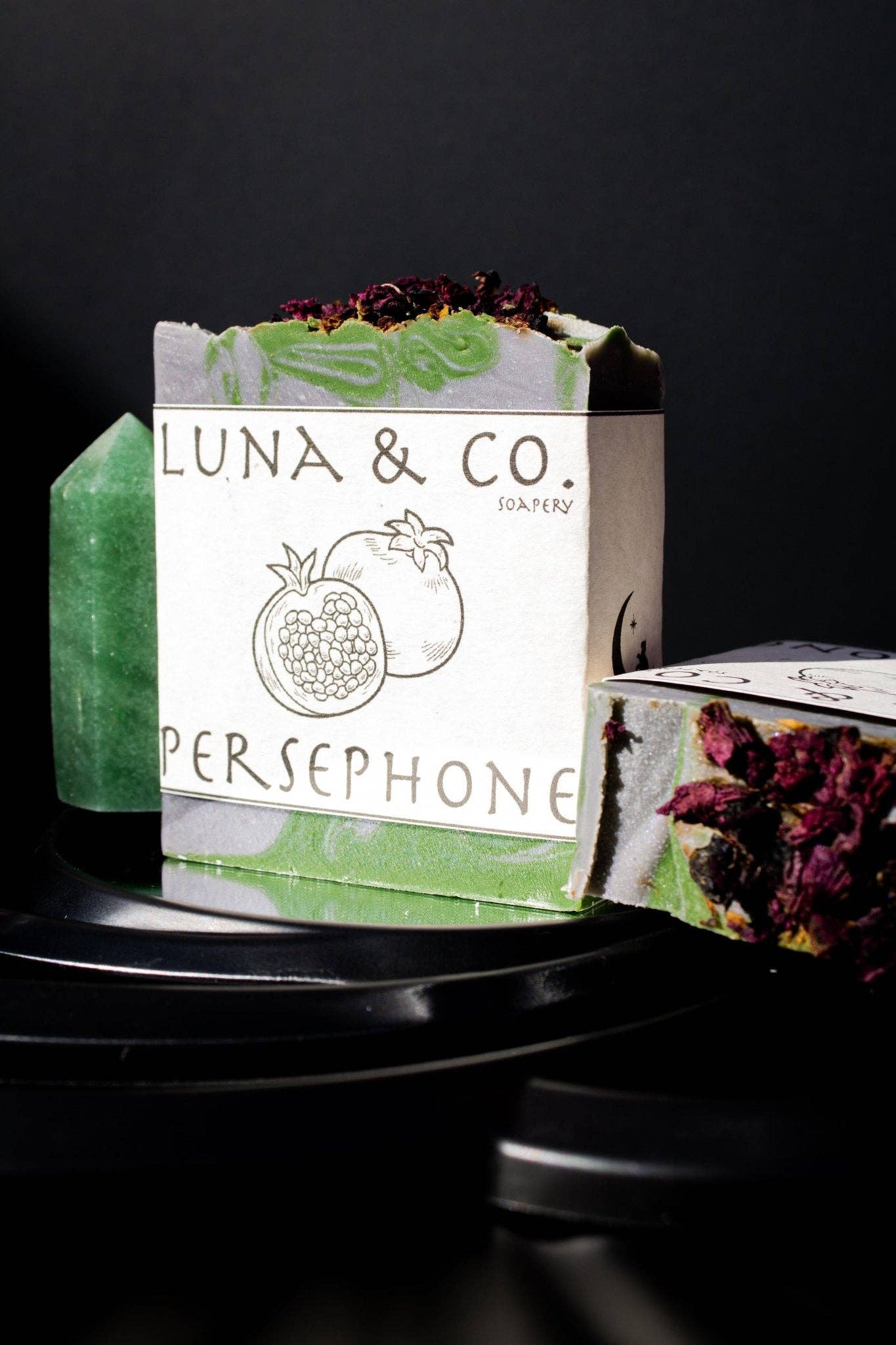 Green soap bar with packaging labeled 'Luna & Co.' on a black background