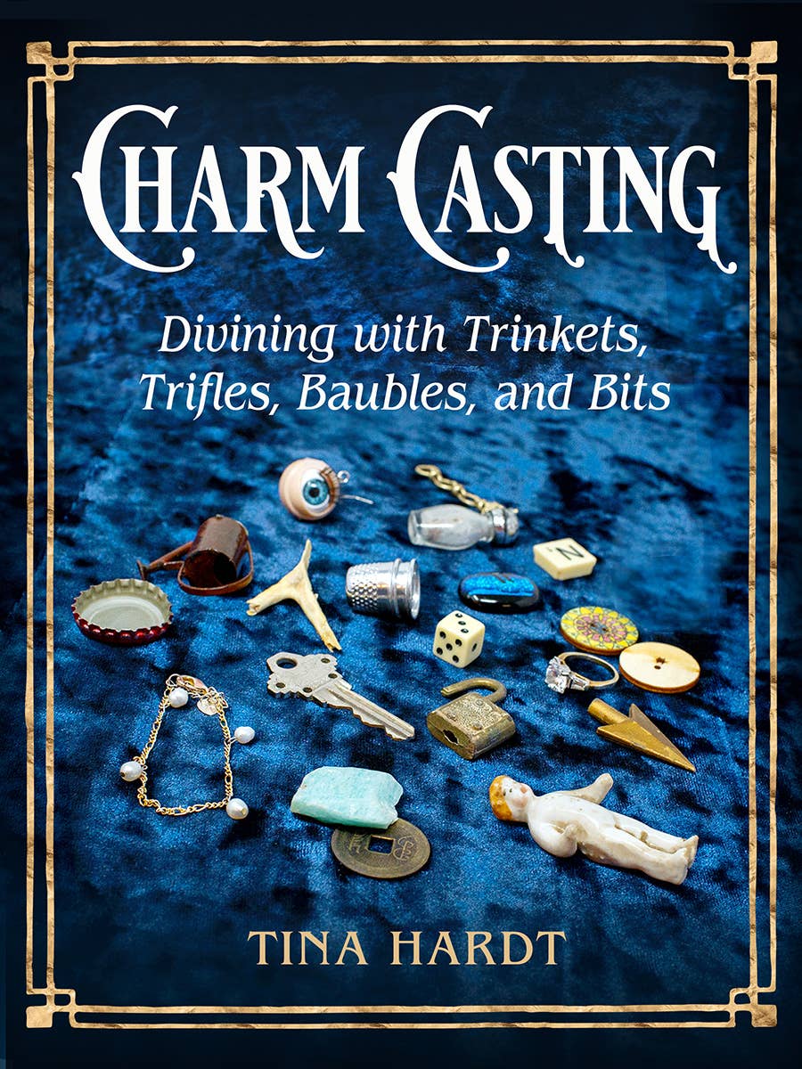 Book cover of 'Charm Casting' with decorative frame and trinkets on a blue background
