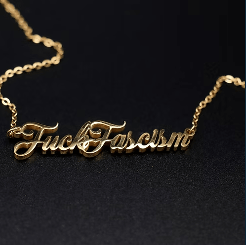 Close up of gold topple and burn fascism necklace.
