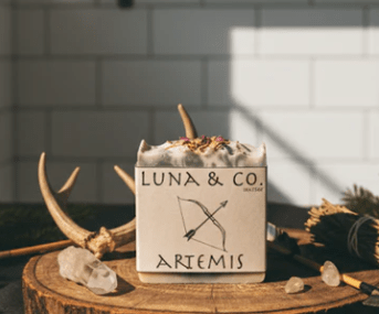 Luna & Co. Artemis product in a box on a wooden surface with decorative elements.