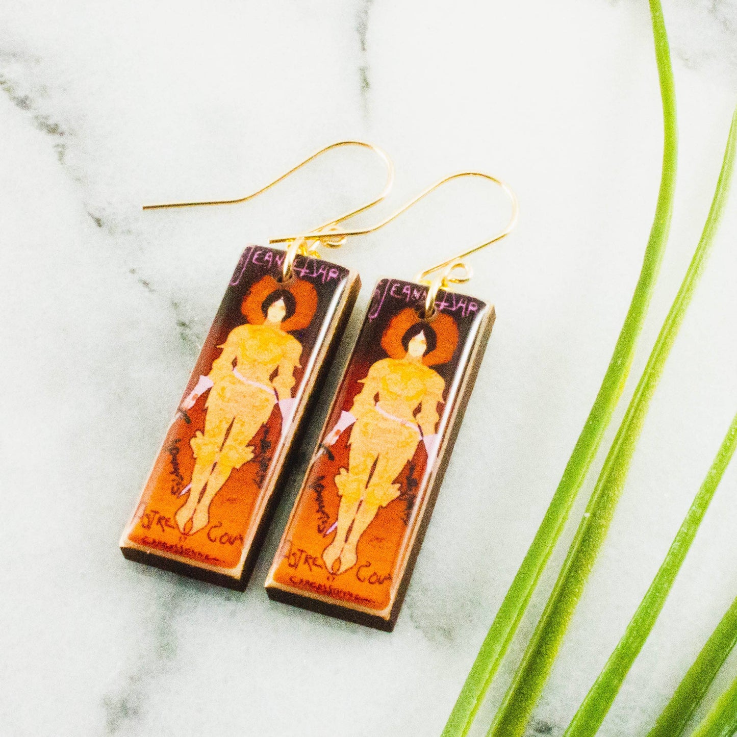 Pair of earrings with artistic design on a marble surface