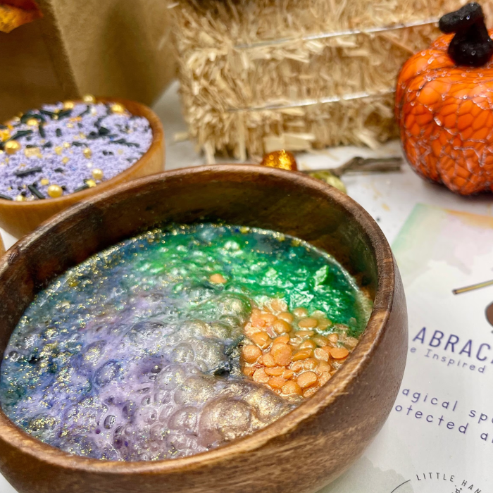Wooden bowl with colorful contents on a table with Halloween decorations.