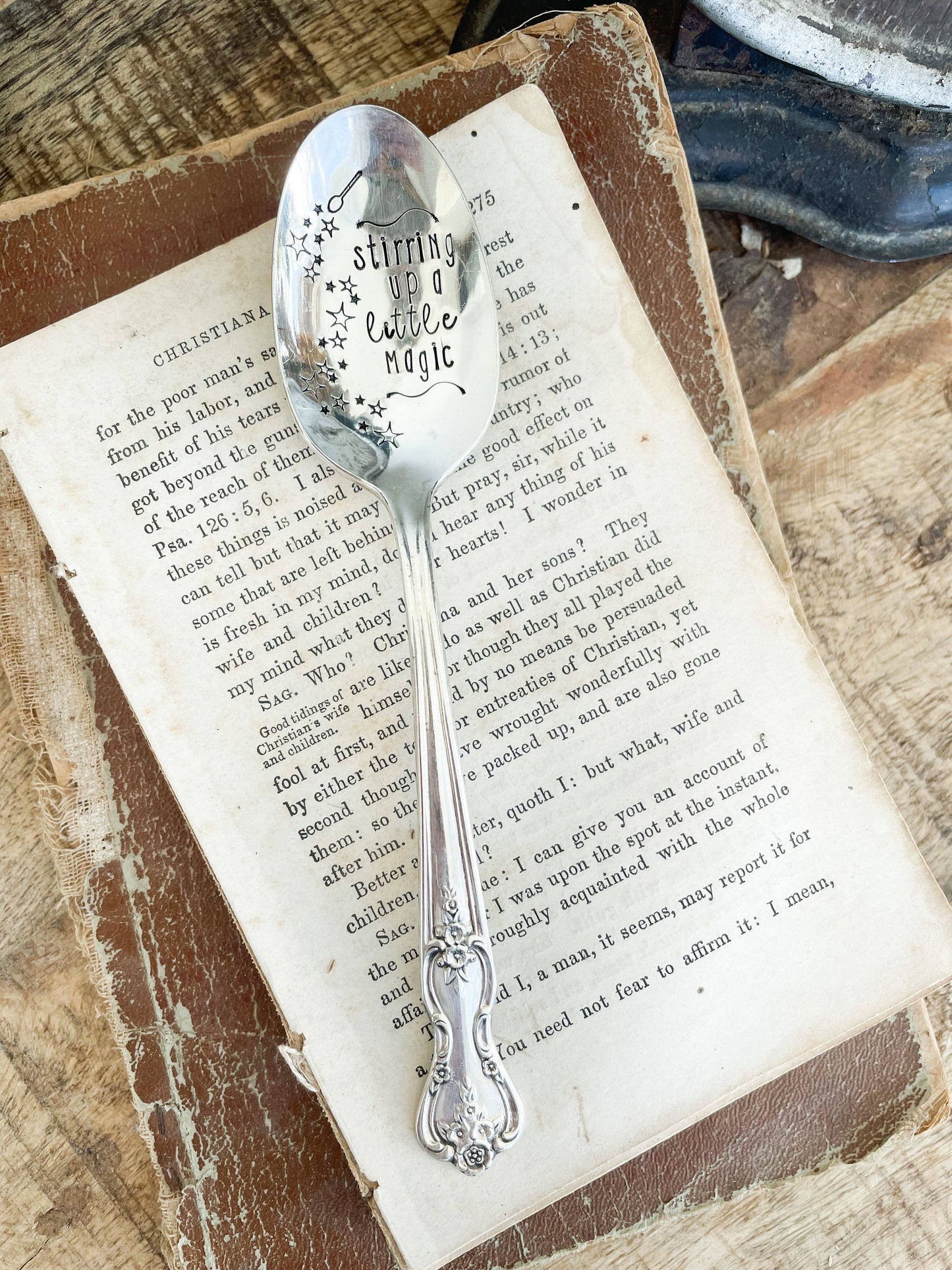 Silver spoon with engraved text on an open book