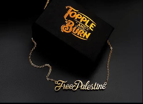 Gold 'Free Palestine' necklace on a black box with 'Topple and Burn' text.