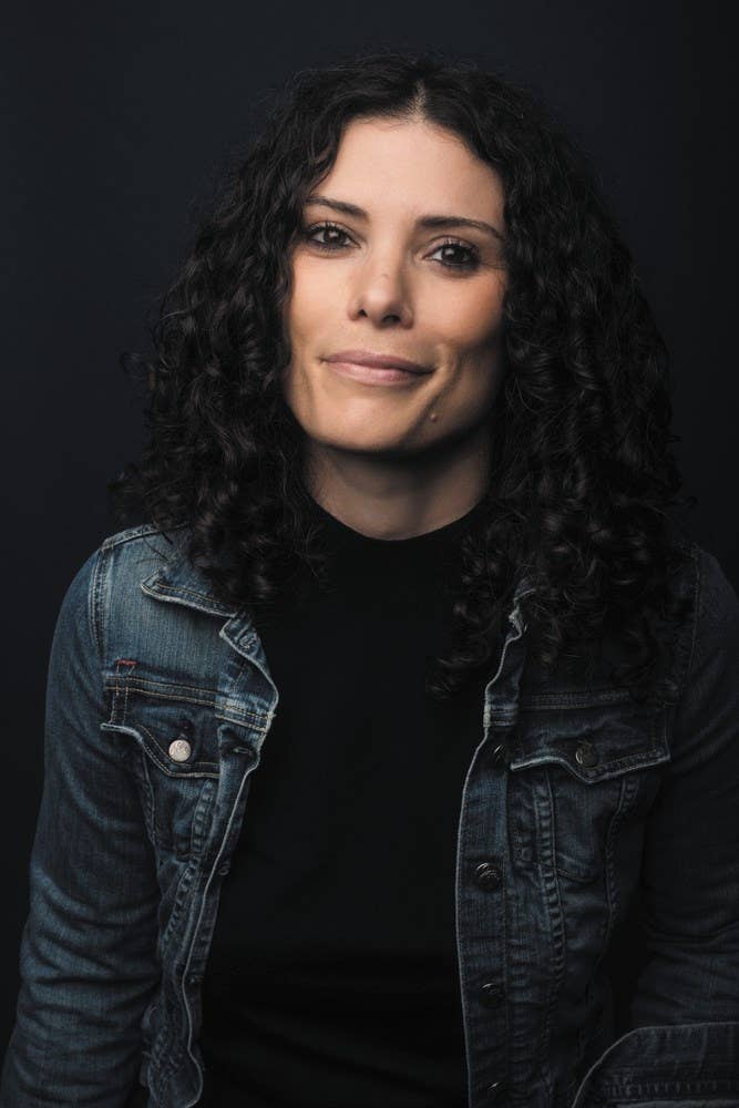 Woman wearing a denim jacket against a black background