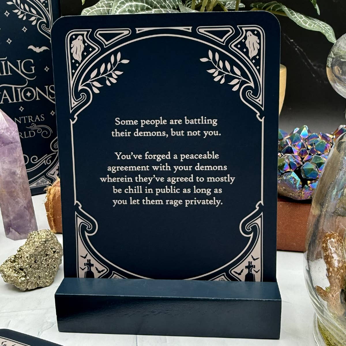 Decorative plaque with motivational quote on a stand, surrounded by decorative items.
