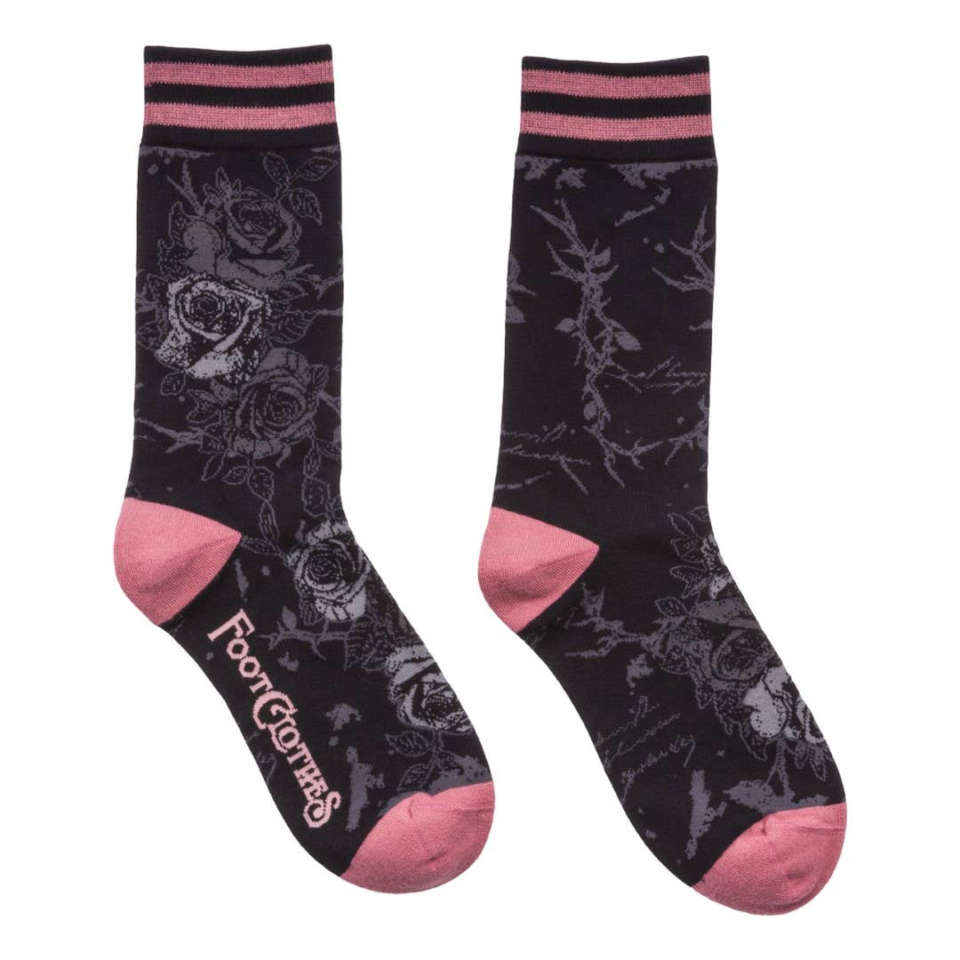 Black socks with pink accents and floral patterns on a white background