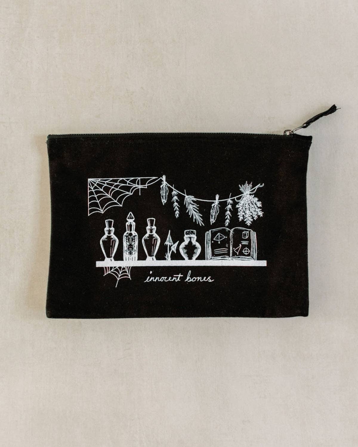 Black pouch with white graphic design on a beige background