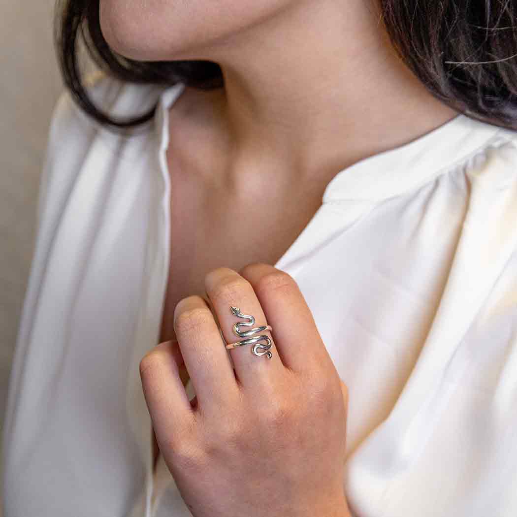 Close-up of a hand wearing a silver ring with a white background