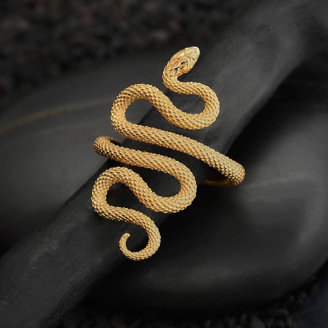 Gold snake-shaped bracelet on a dark background