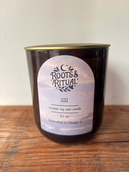 Roots & Ritual candle on a wooden surface with a white background