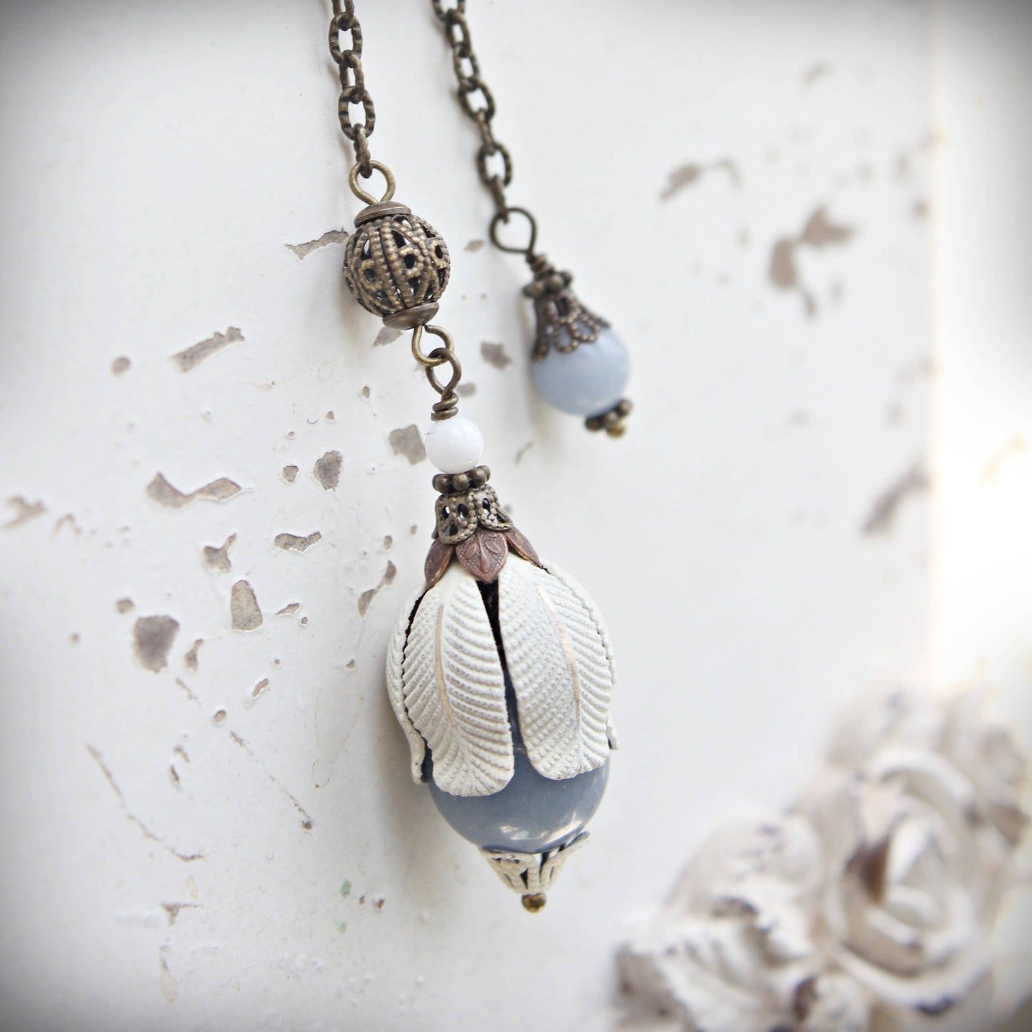 pendulum with a shell pendant on a textured white background