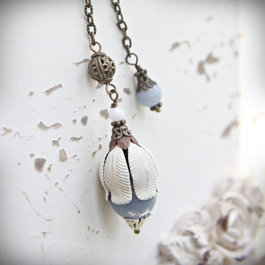 pendulum with a shell pendant on a textured white background