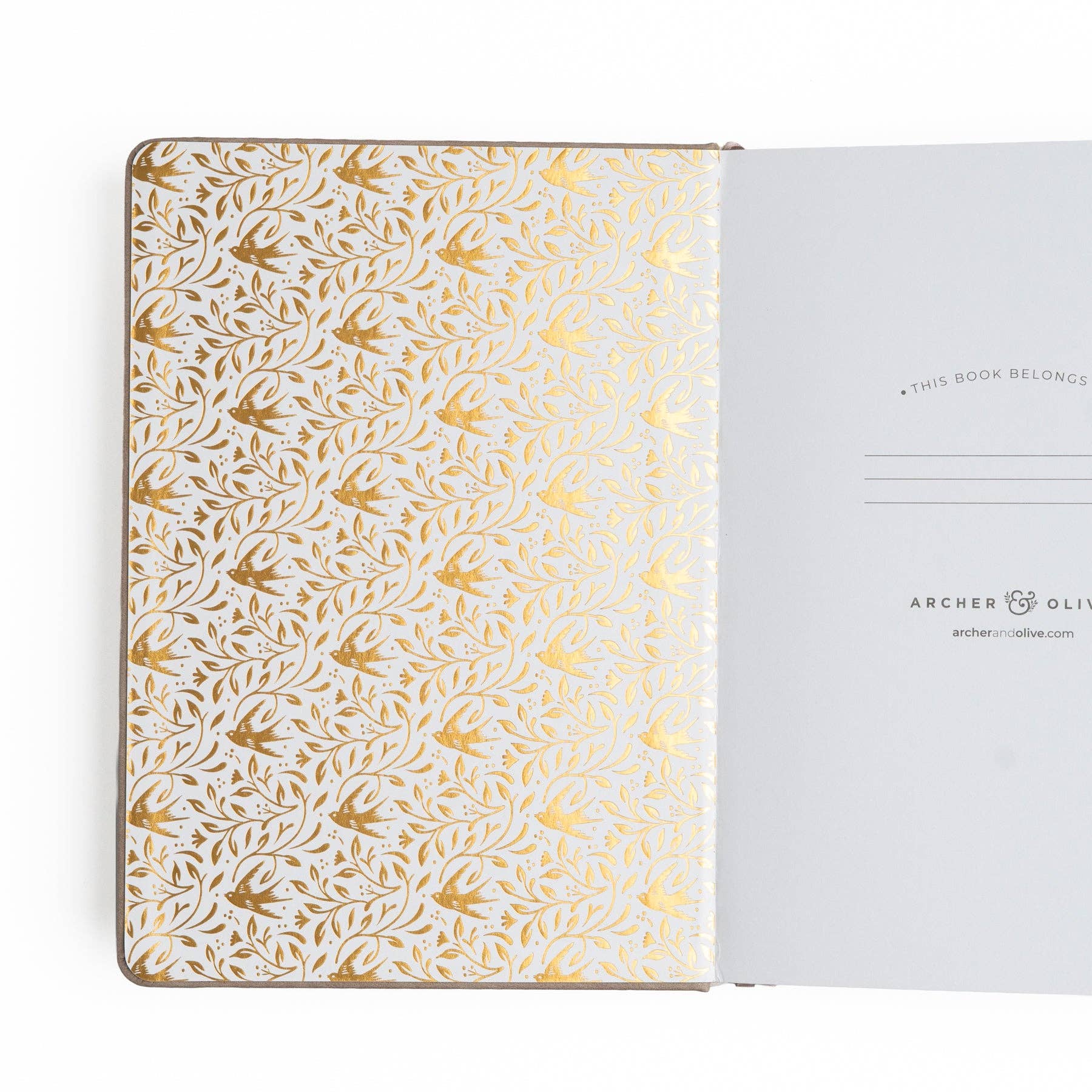 Notebook with gold floral pattern on cover and white interior pages.