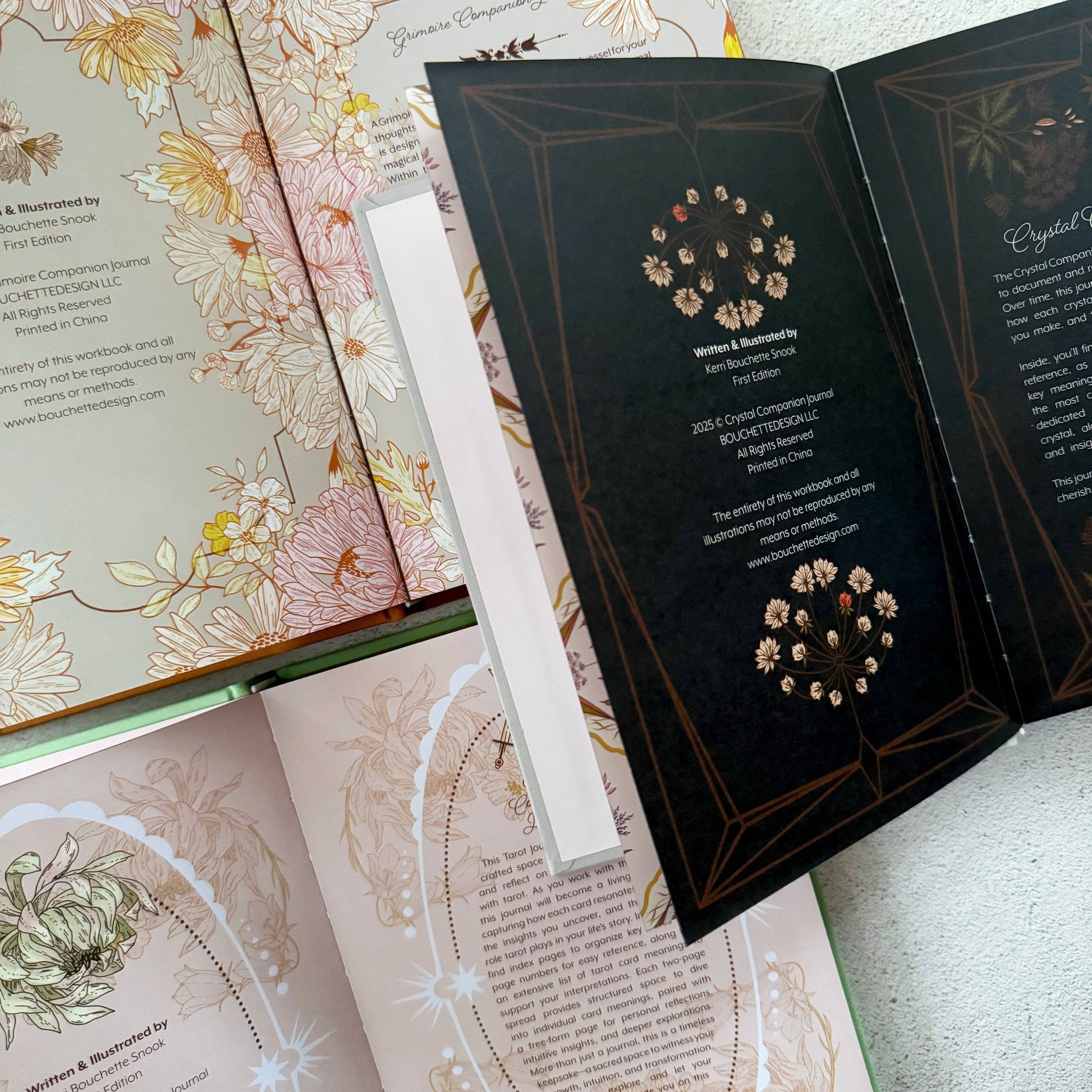 Open book with decorative pages and a white bookmark on a textured surface