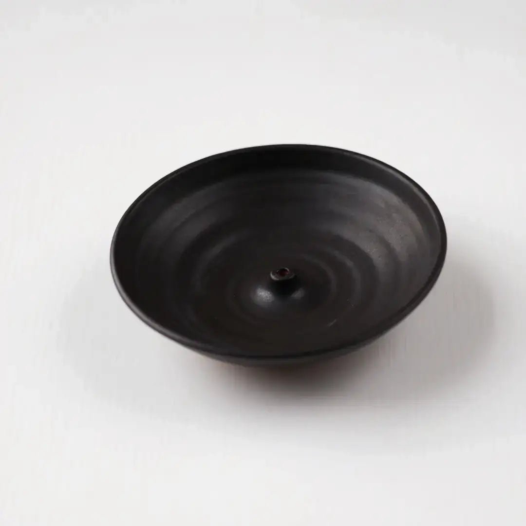 Black ceramic incense holder on a white background