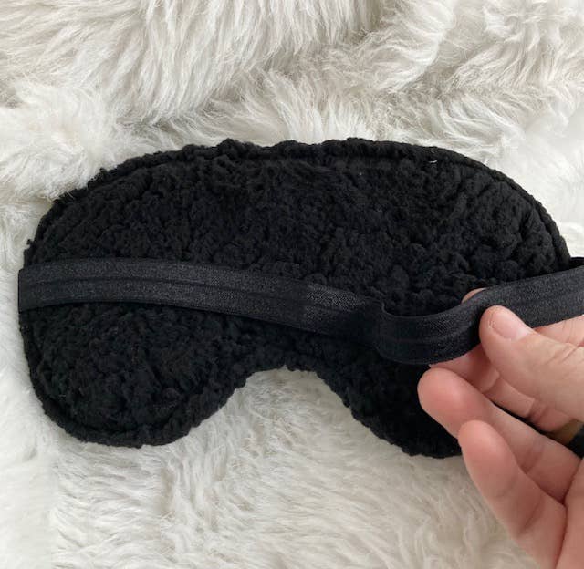 Back of sleep mask on a fluffy white background.