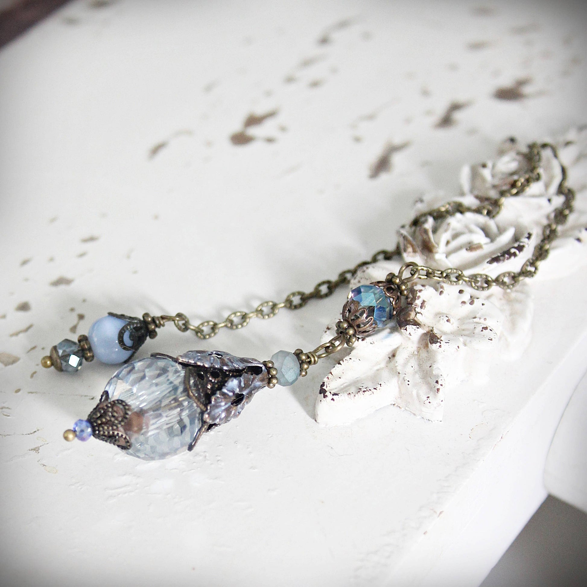 Necklace with blue beads and crystals on a textured surface