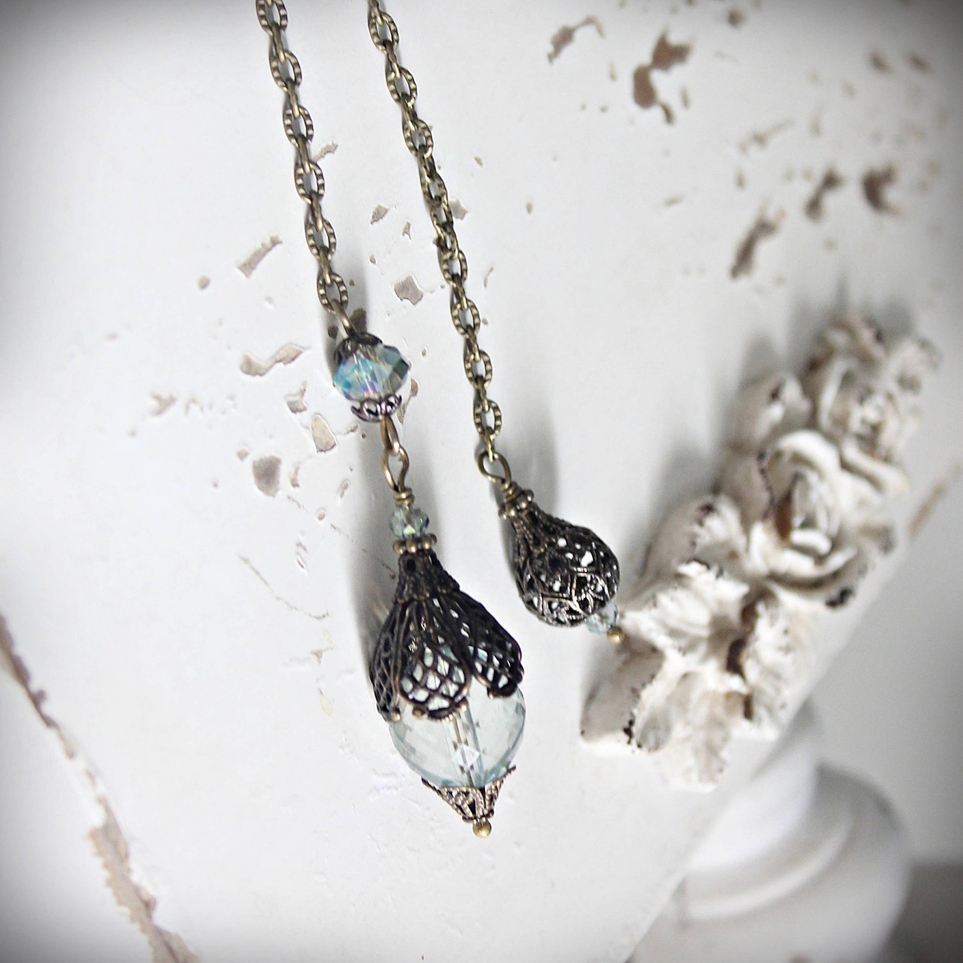 Pendulum with decorative beads on a textured white surface