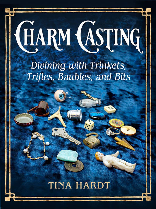 Book cover of 'Charm Casting' with decorative frame and trinkets on a blue background