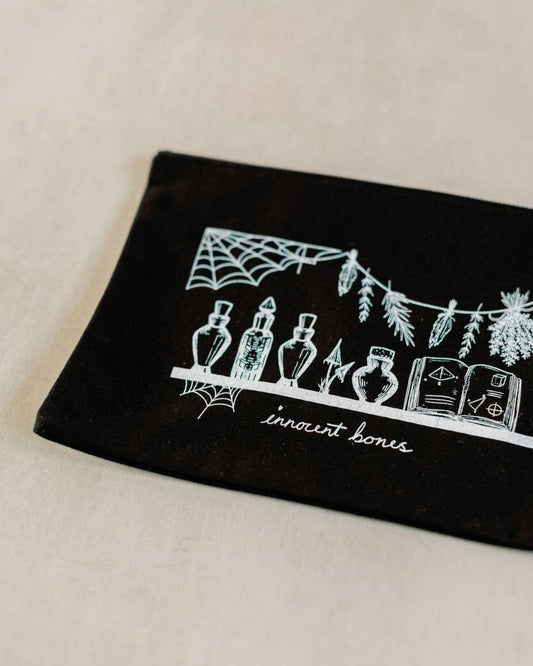 Black pouch with white graphic design on a beige background