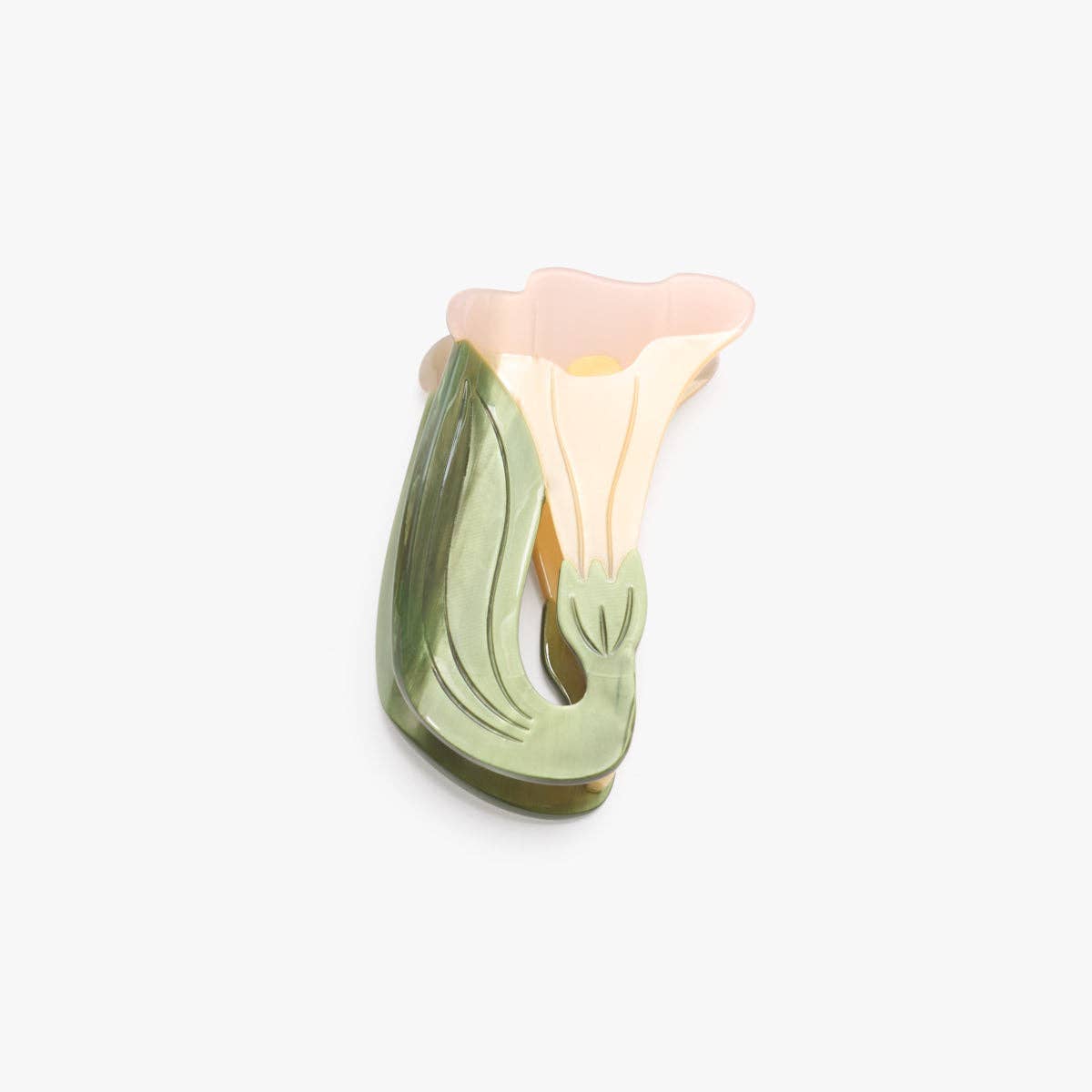 A small sculptural floral object with layered flower-like forms in soft pastel tones, including pink, cream, and light green, photographed on a plain light gray background.