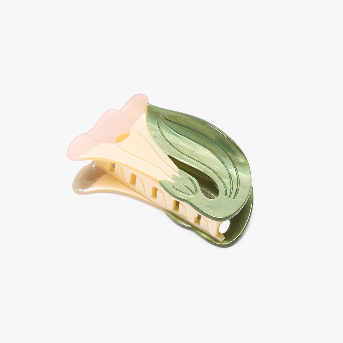 A floral hair claw clip featuring a pale pink flower bloom and a glossy green leaf design on a cream-colored plastic base, set against a plain light gray background.
