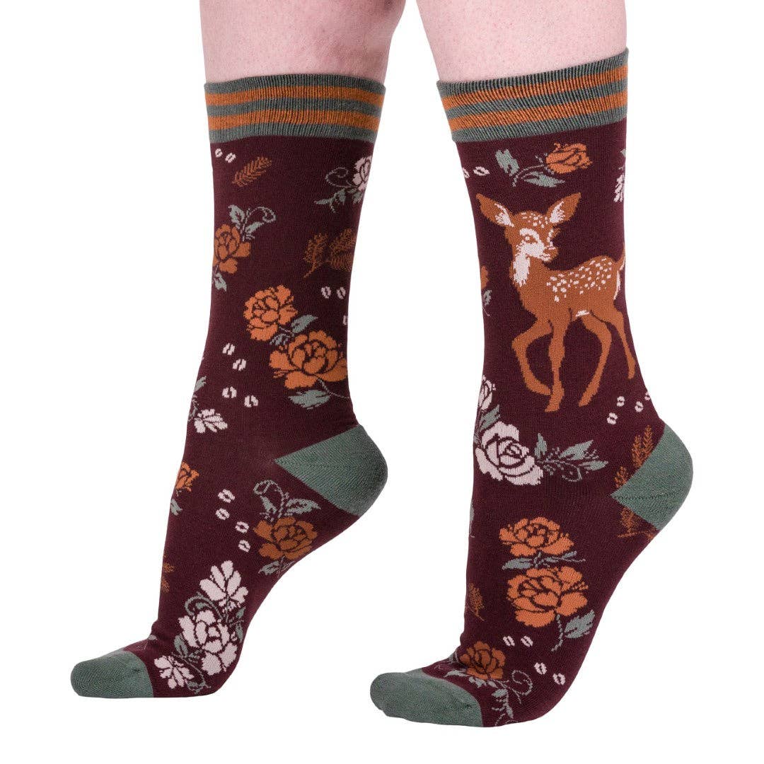 Maroon socks with deer and floral patterns on a white background