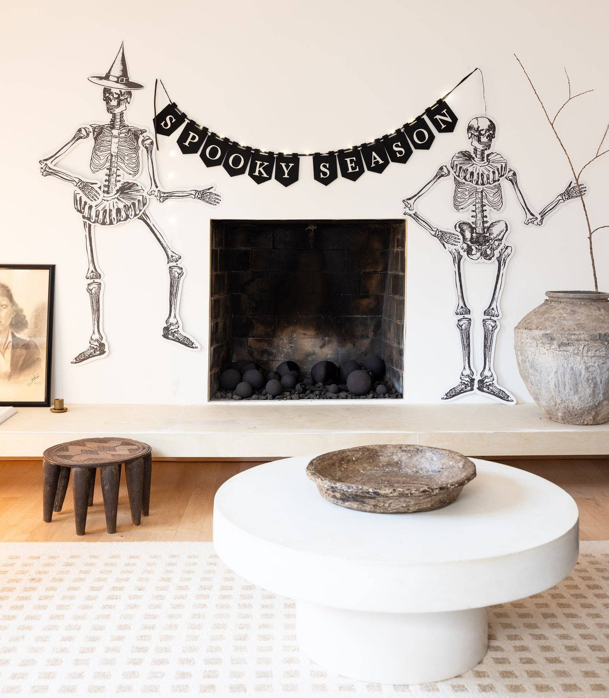 Living room with Halloween decorations including skeletons and a 'Spooky Season' banner.