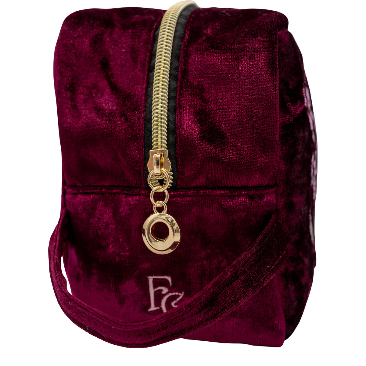 A small velvet zippered pouch in deep burgundy with a gold zipper, gold zipper pull, and a silver embroidered monogram logo on the front, shown against a plain white background.