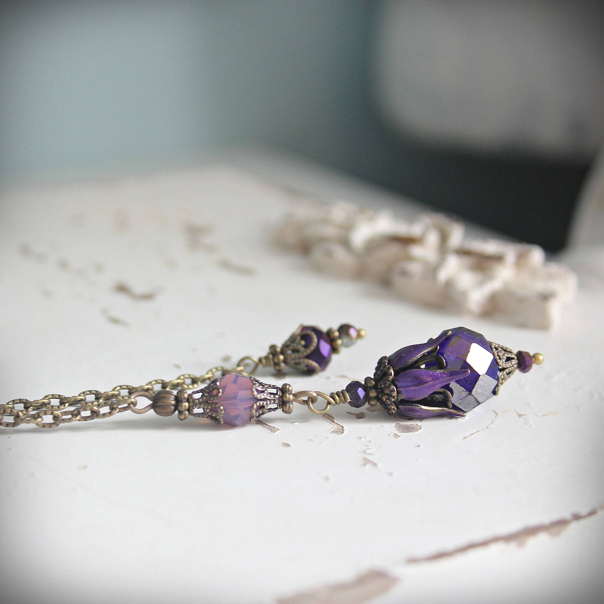 Pendulum with purple gemstones on a textured surface