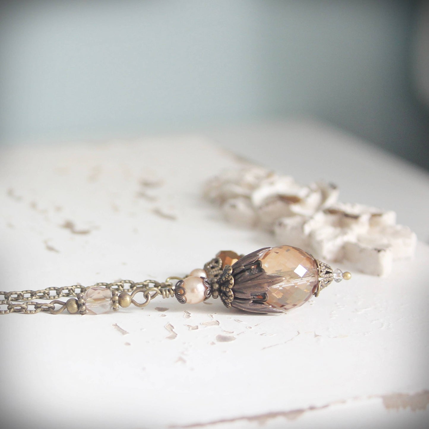 Pendulum with a large brown bead on a light surface