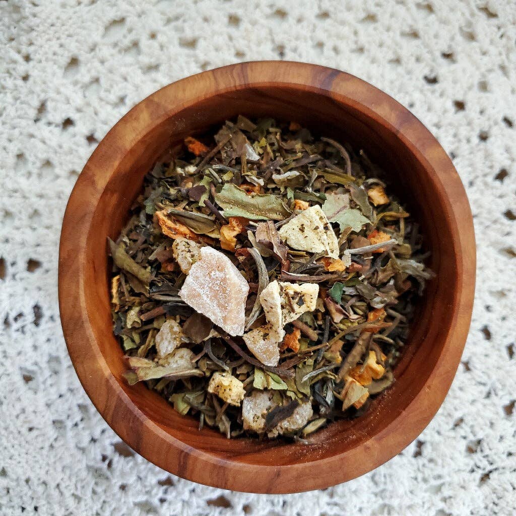 Wooden bowl filled with dried herbs and spices on a textured surface