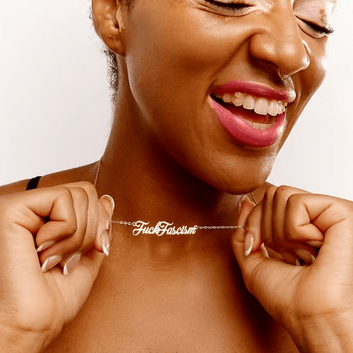 Model holding a fuck fascism necklace.