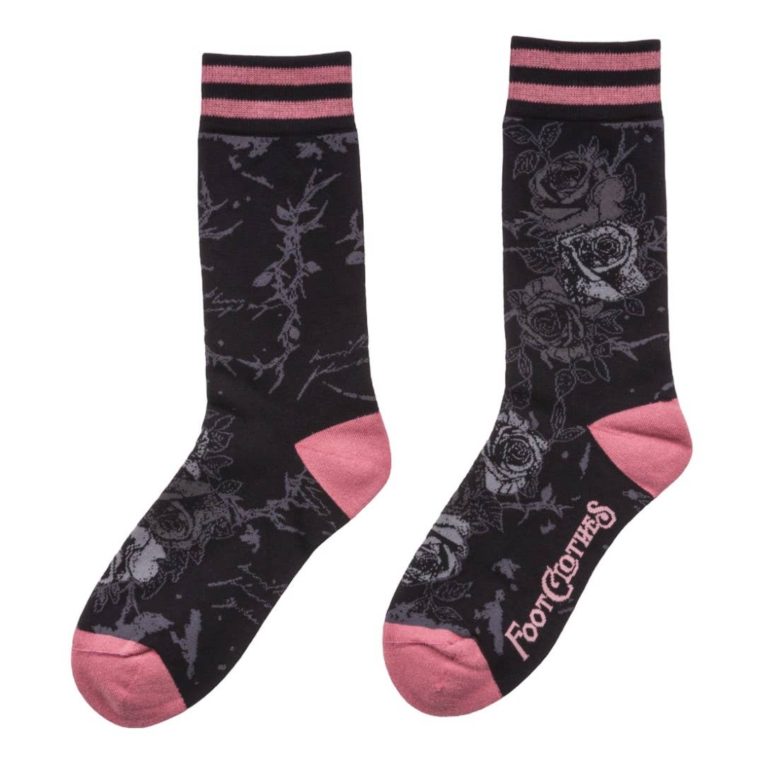 Black socks with pink accents and floral patterns on a white background