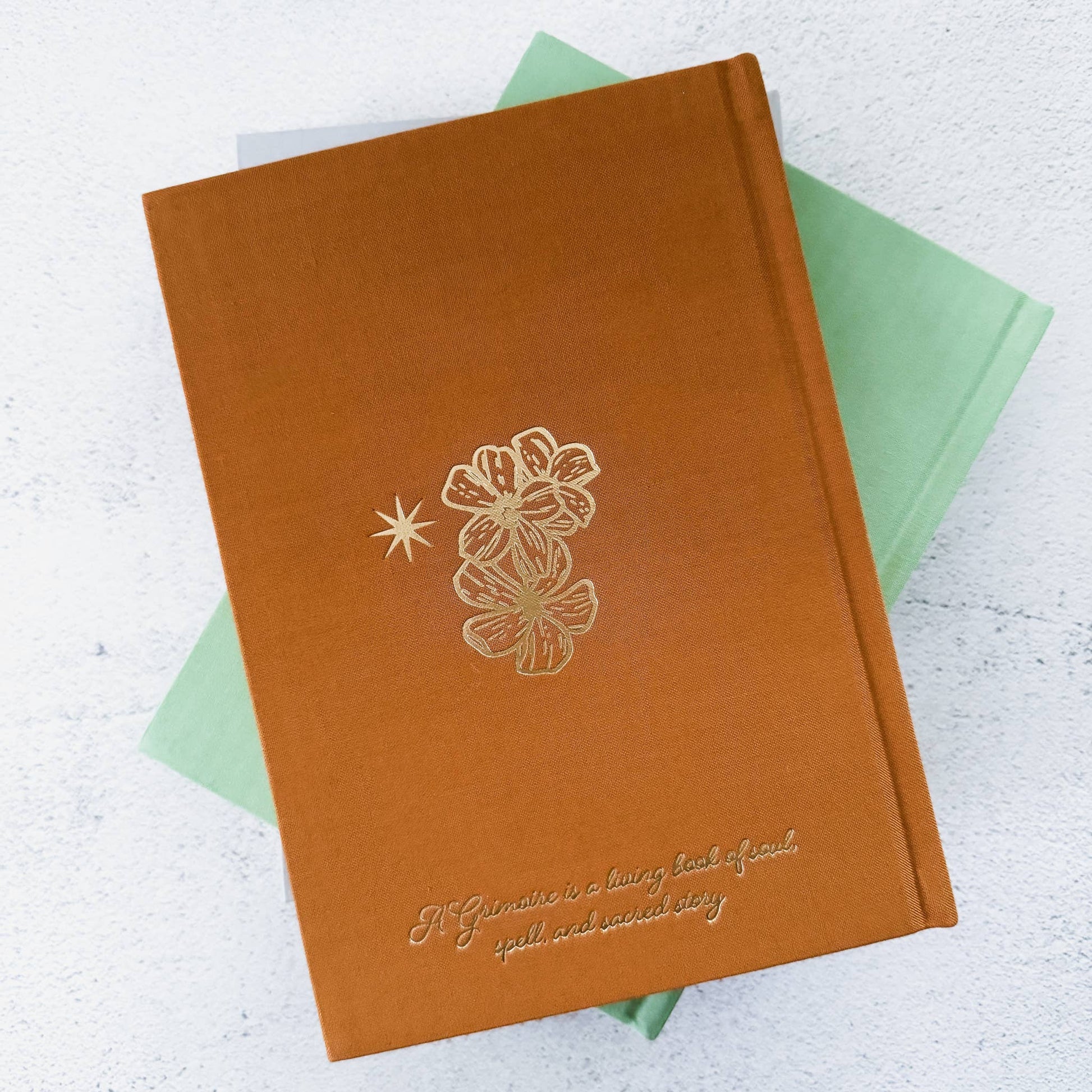 Brown notebook with floral design and text on a light background