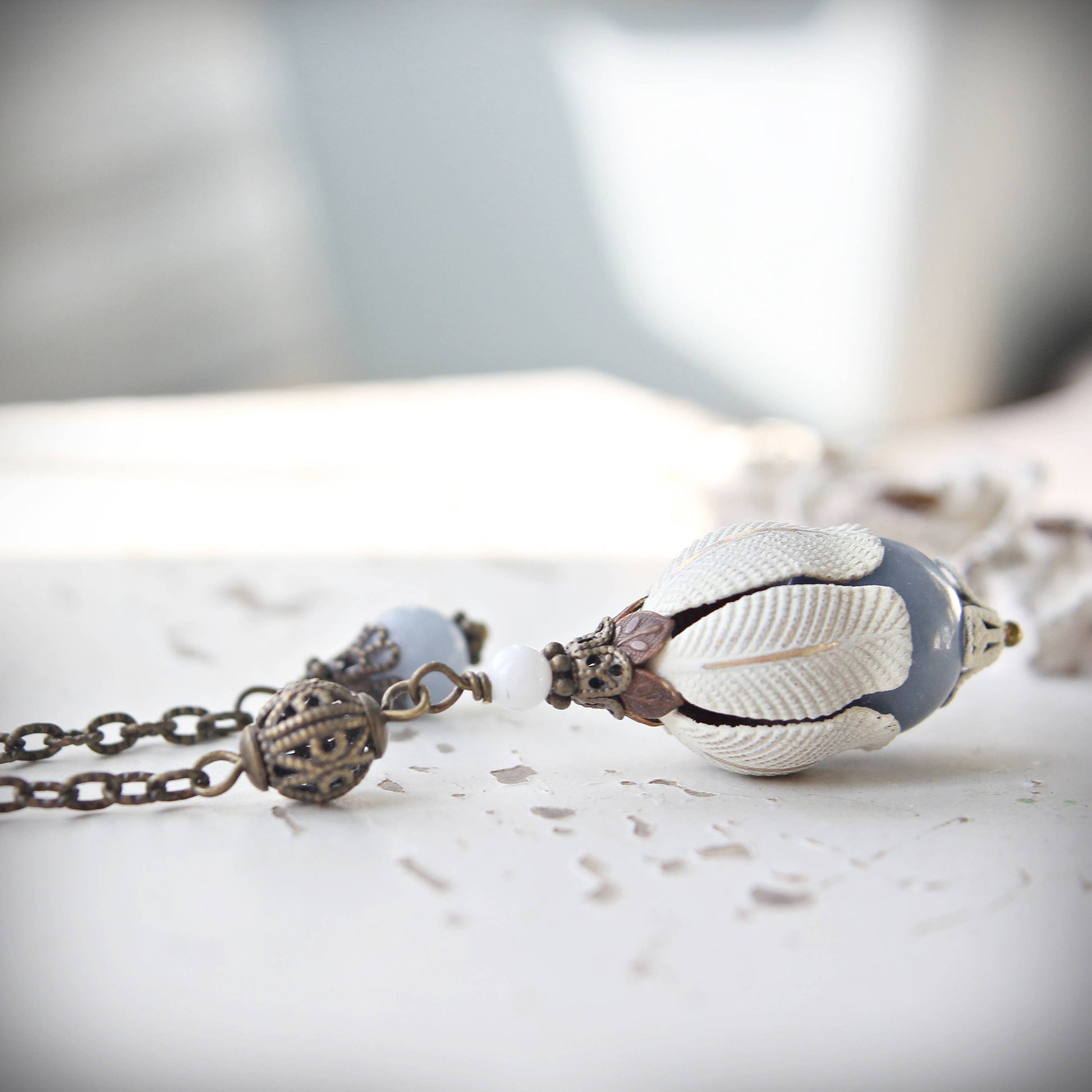 Pendulum with an Agelite stone on a marble surface