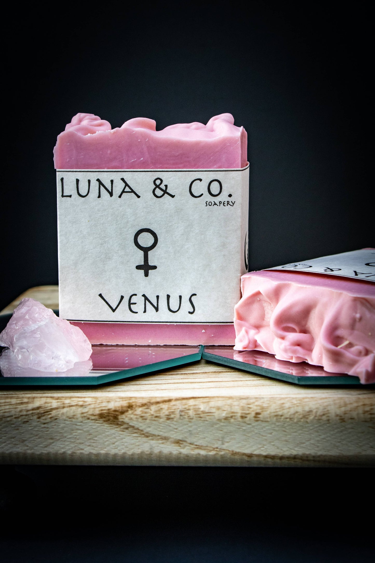 Pink soap bar with 'Luna & Co.' branding on a dark background