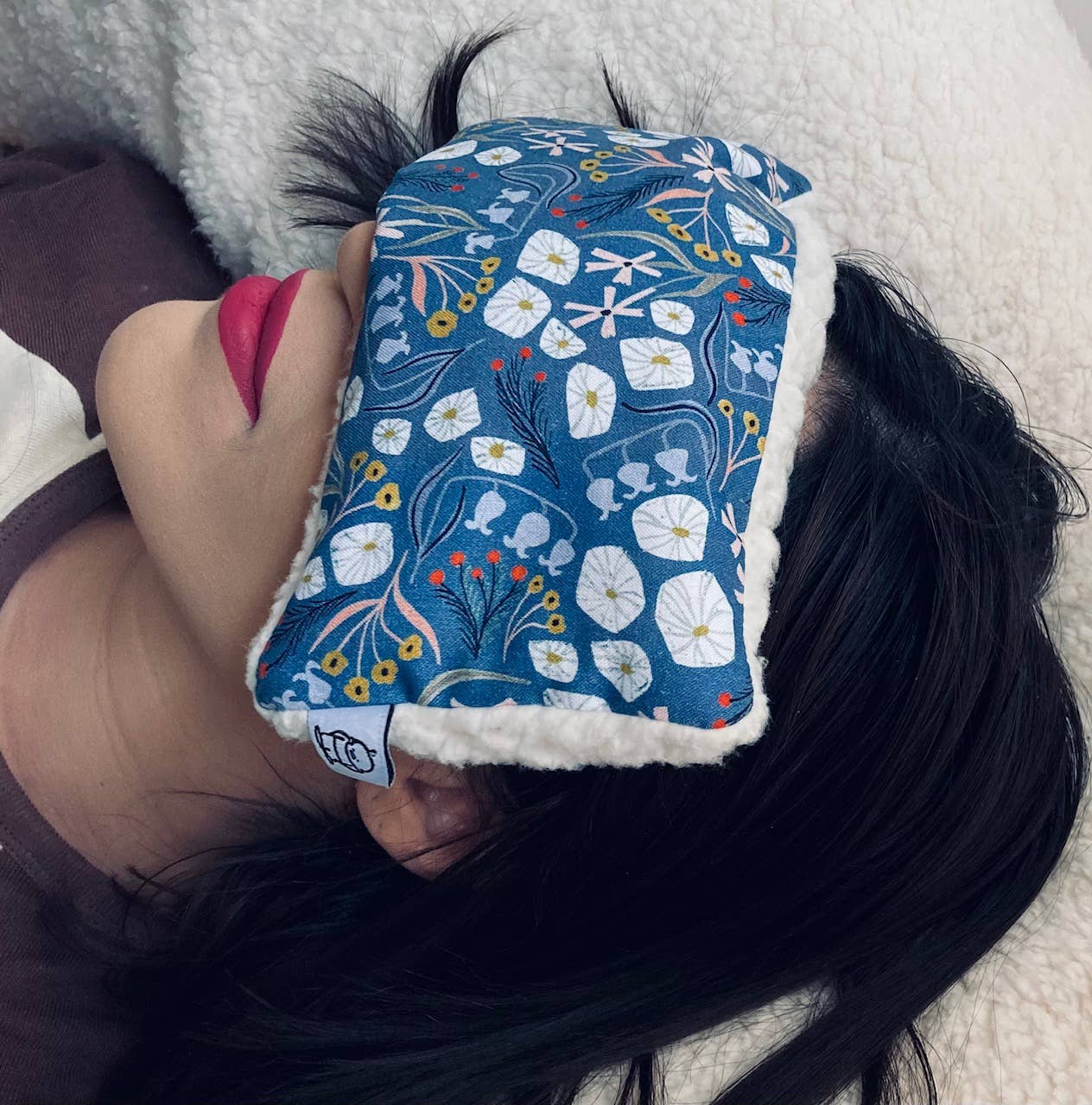 Person wearing a deep rest eye pillow.