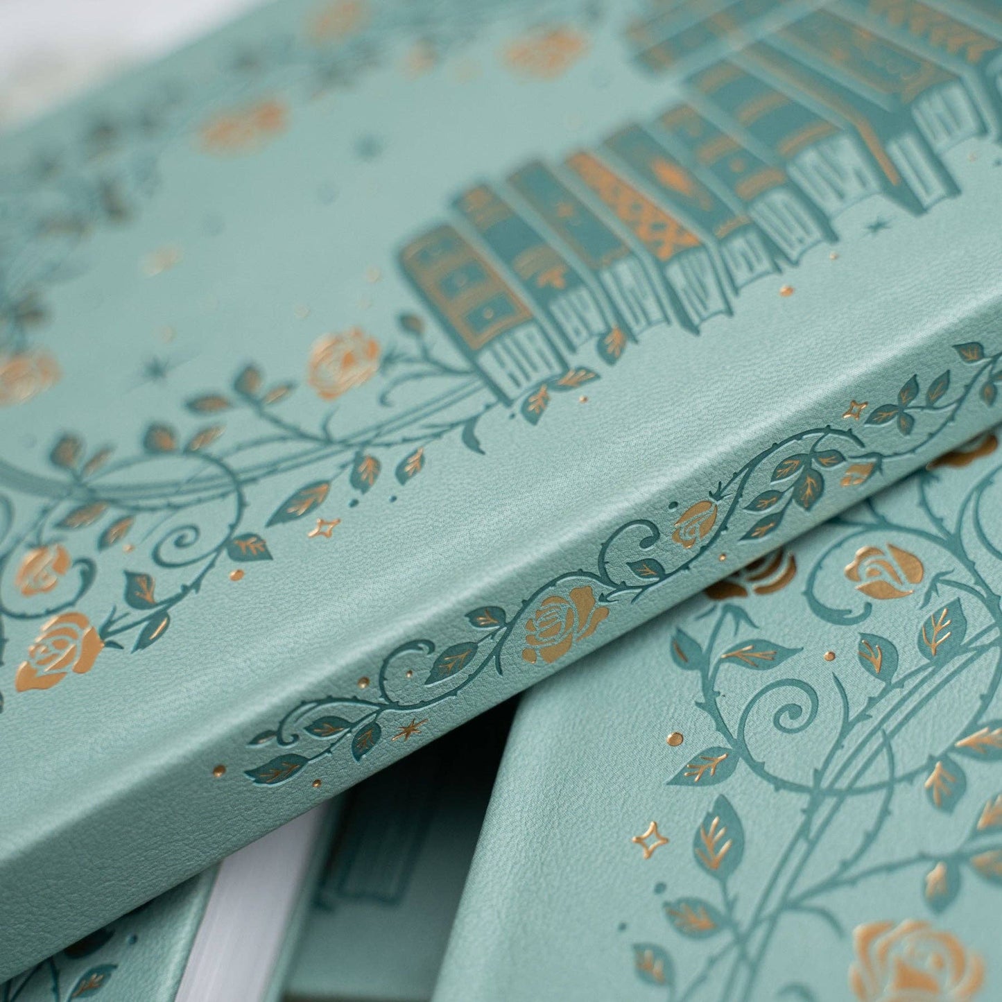 Teal boxes with gold floral patterns on a white background