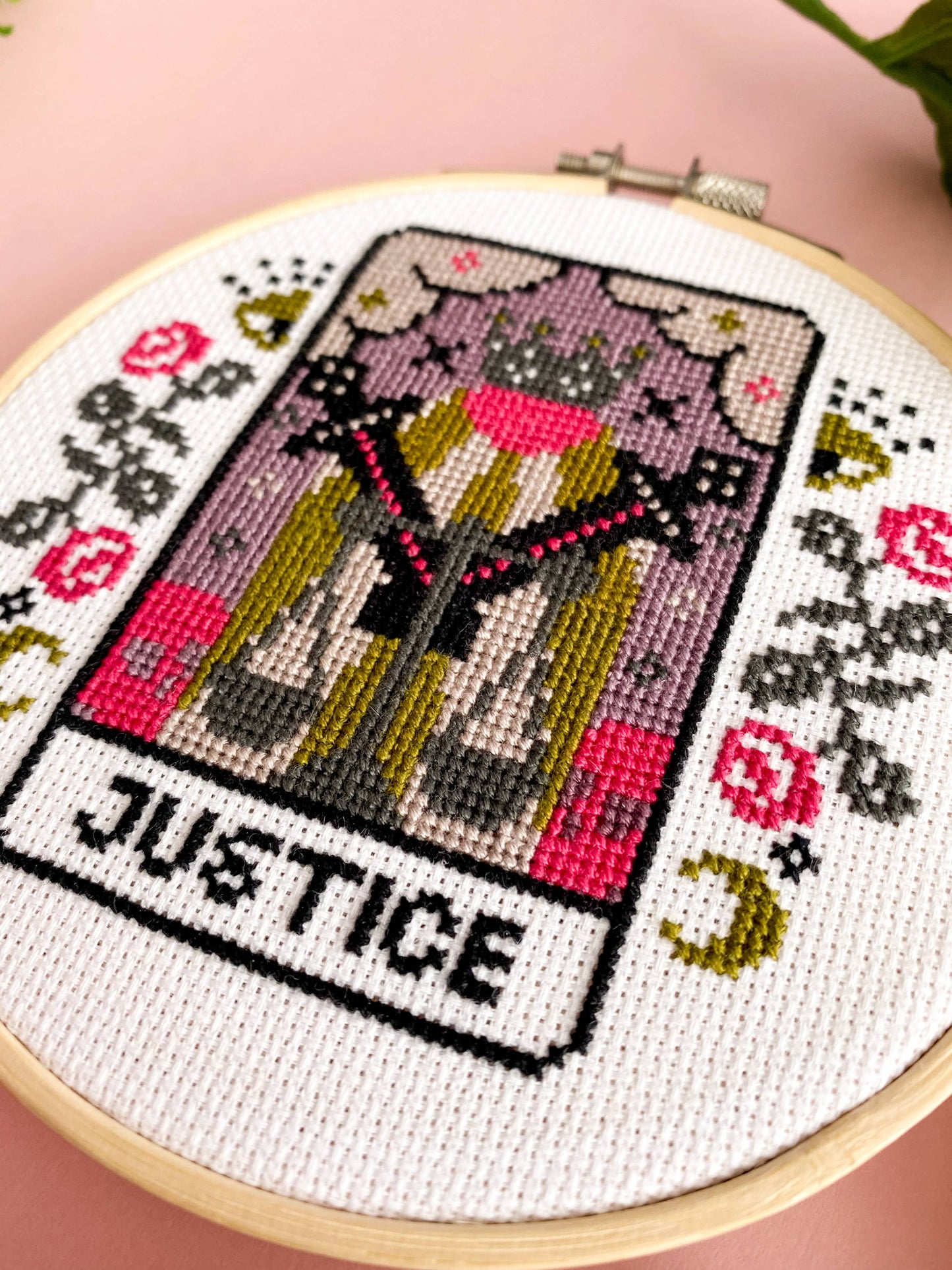 Cross-stitched tarot card design labeled 'Justice' in an embroidery hoop.