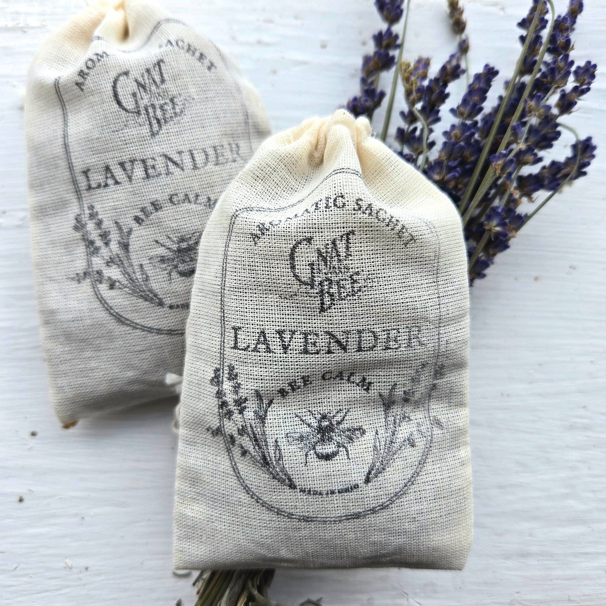 Two lavender sachets with bee design on a white background