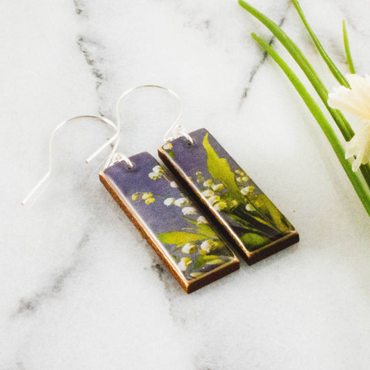 Rectangular earrings with floral design on a marble surface