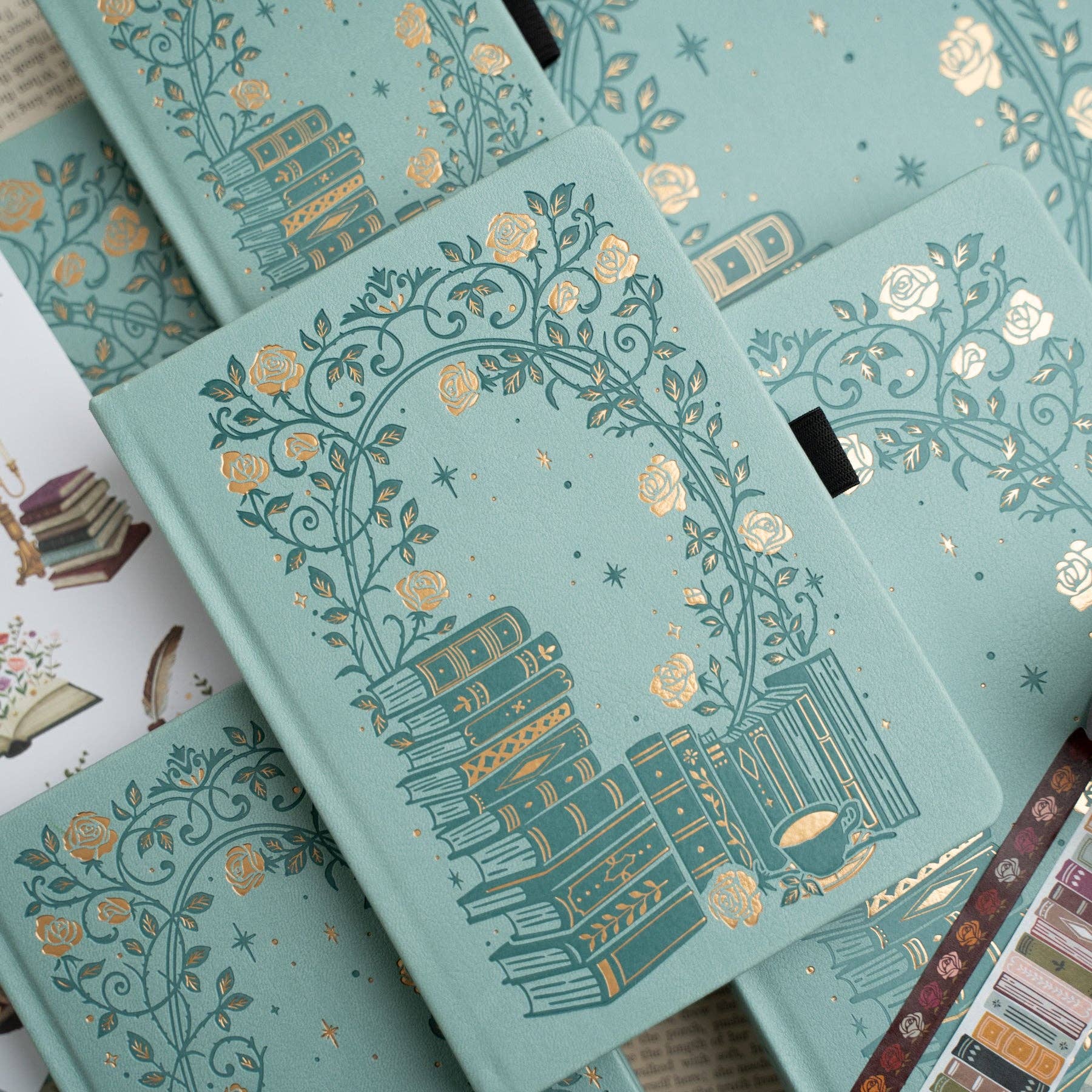 Decorative notebooks with intricate gold designs on a light blue background