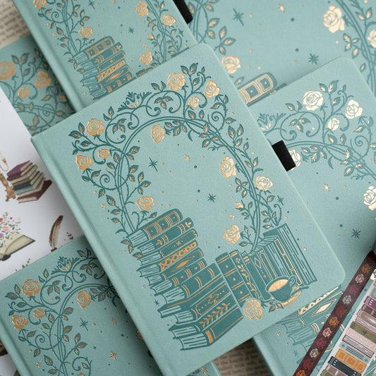 Decorative notebooks with intricate gold designs on a light blue background