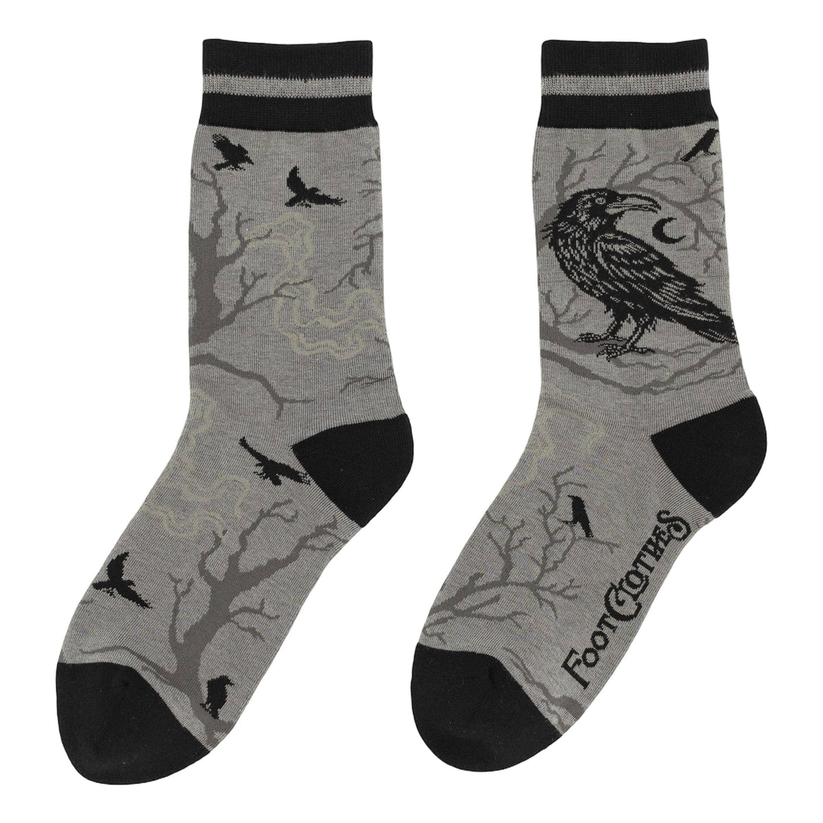 A pair of gray crew socks with black heels, toes, and cuffs, featuring a graphic print of a raven, moon, and bare tree branches.