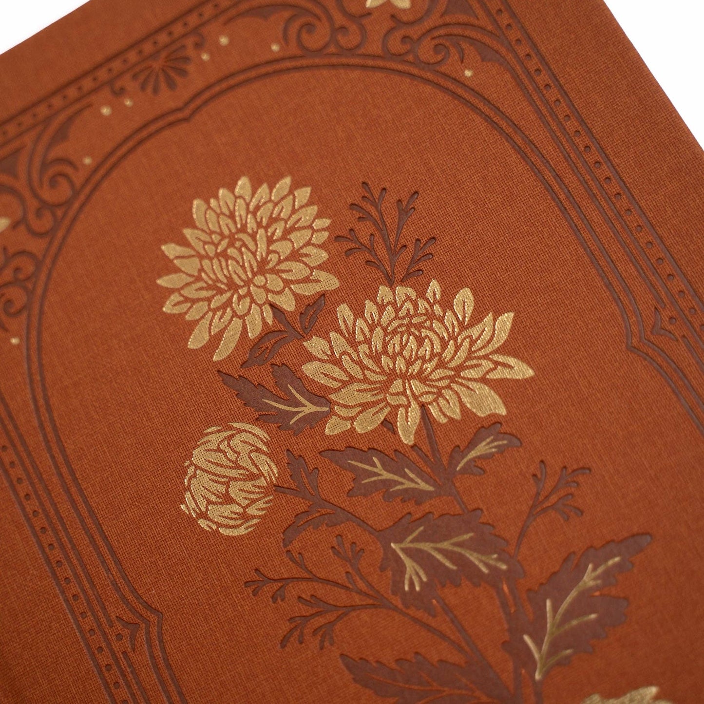 Decorative red journal with floral embossing on a white background