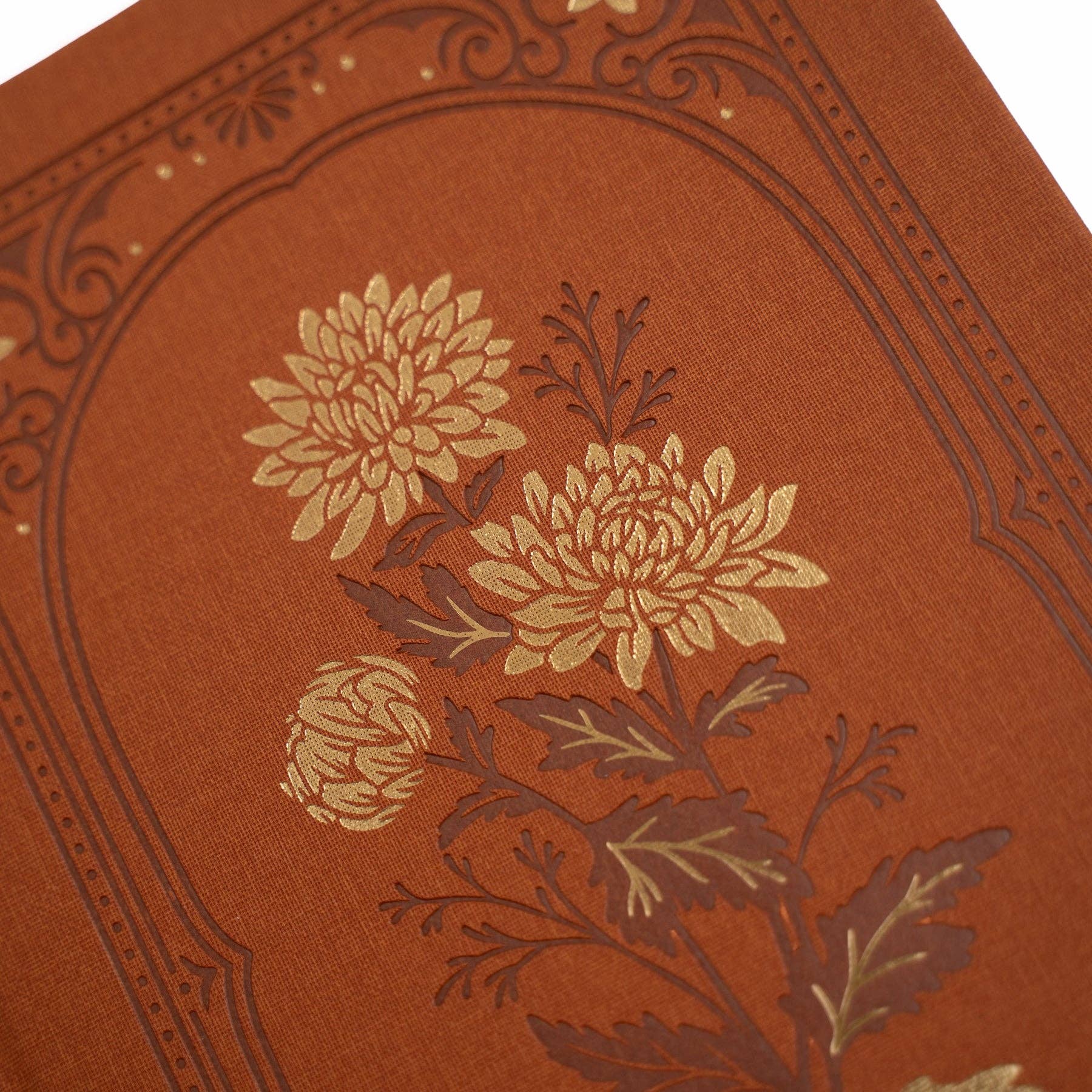 Decorative red journal with floral embossing on a white background