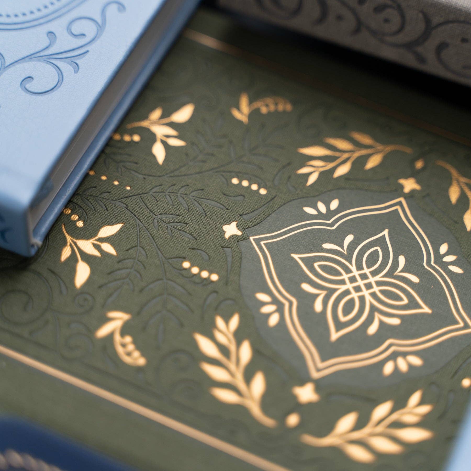 Close-up of a green journal with gold embossed design. 